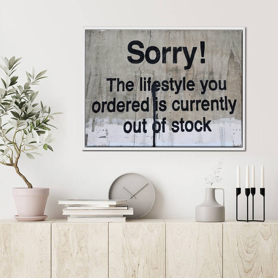 white frame banksys statement canvas print hanging on the wall
