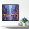 a black frame wall art painting showing the bustling city streets on a rainy night hangs on the wall of a warmly decorated room