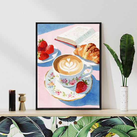 black frame wall art canvas painting depicts a cozy scene with latte art coffee, strawberries, croissants and an open book.