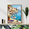 light oak color frame wall art canvas painting showing a sunny seaside town with a table of red wine and flowers on the pier and a cat.
