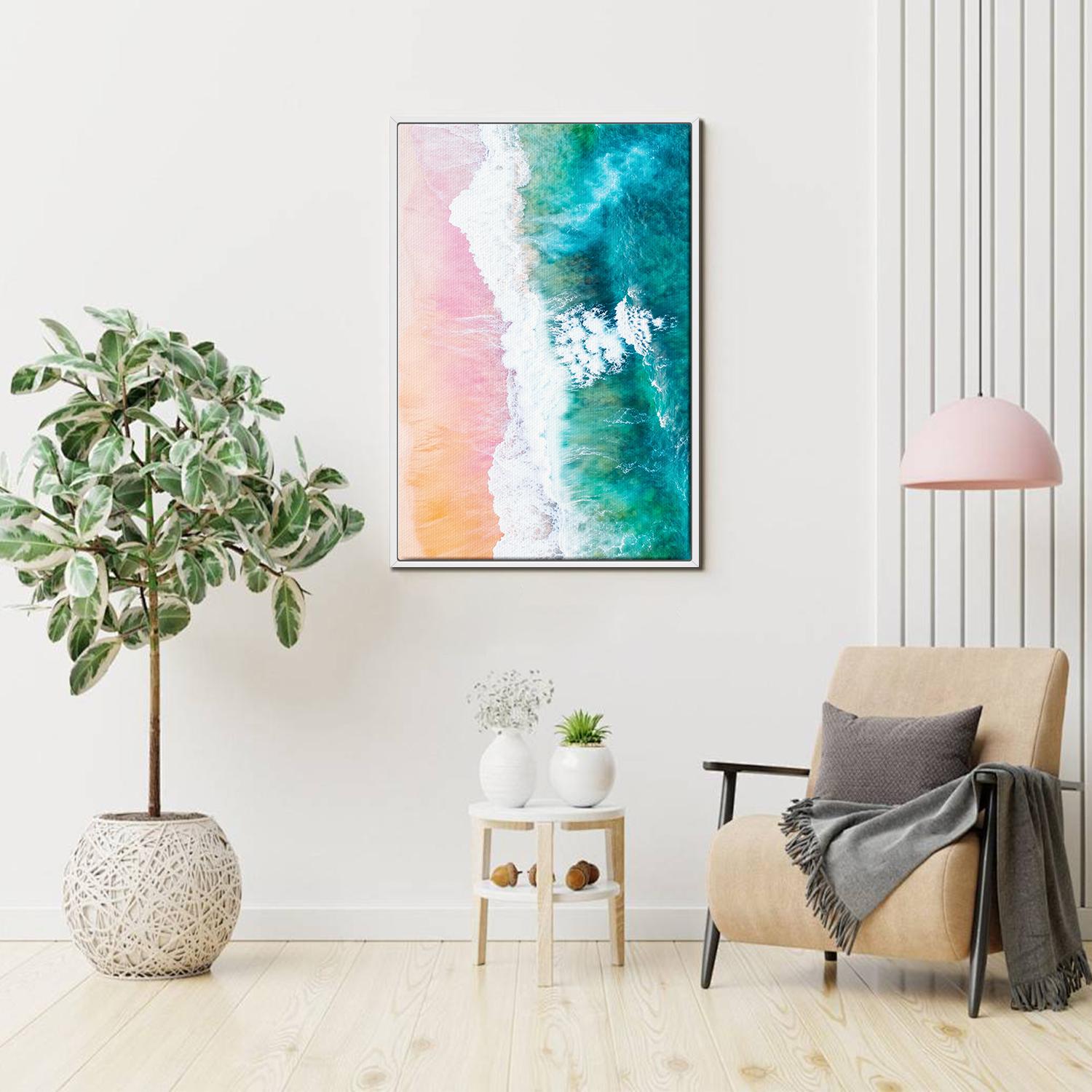 white frame wall art canvas depicts pink sand beach and white waves
