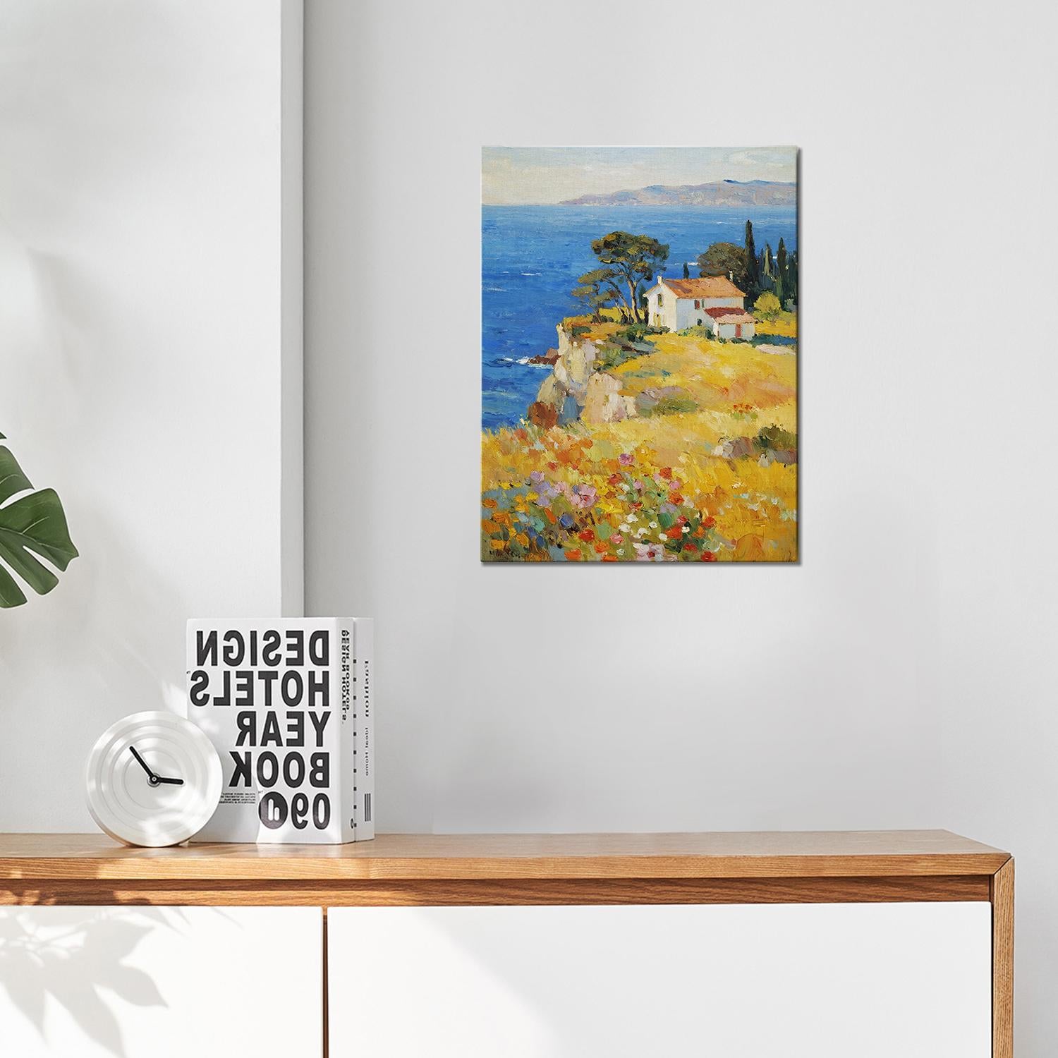 wall art painting hang on the wall depicting a cliffside cottage by the sea