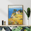 light oak color frame wall art painting depicting a cliffside cottage by the sea