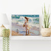 wall art painting on the table depicts a woman in a flowing long dress walking on the beach, accompanied by seagulls.