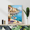 white frame wall art canvas painting showing a sunny seaside town with a table of red wine and flowers on the pier and a cat.